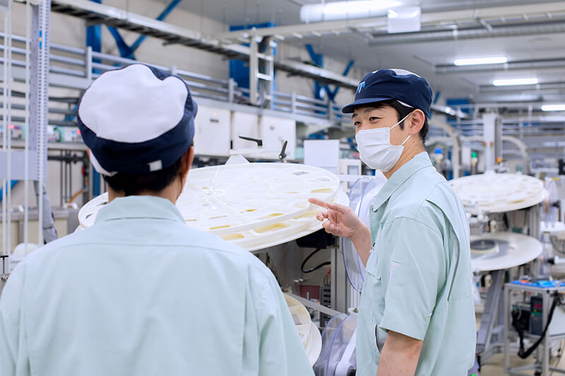 テーブルを囲んで会話する社員