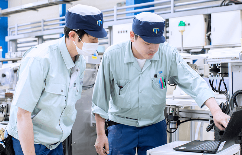 生産ラインの調整について相談する社員